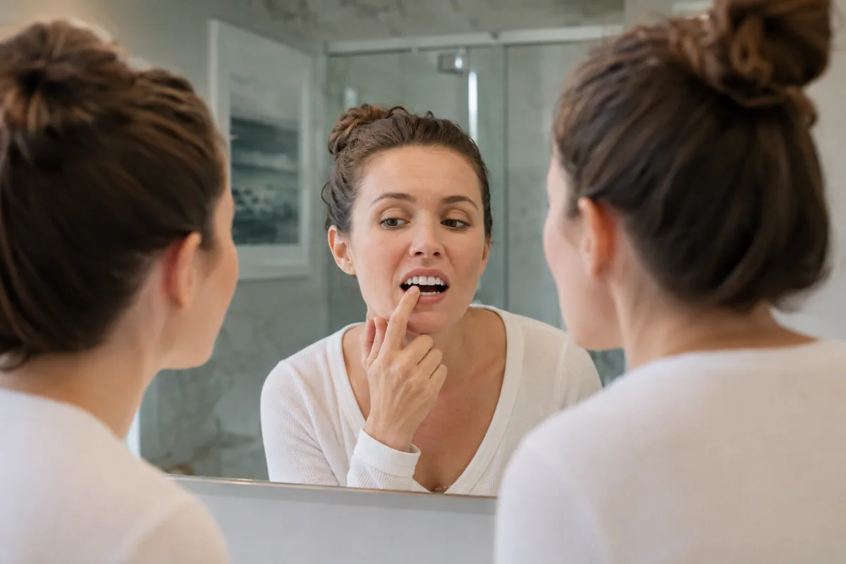 Adult checking a chipped front tooth before calling a Port Dover dentist