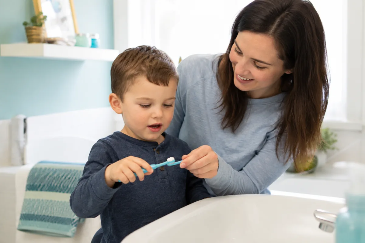 Parent helping a young child brush to prevent cavities in Norfolk County