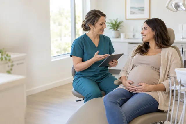 Pregnant adult seated upright while discussing dental care with a clinician