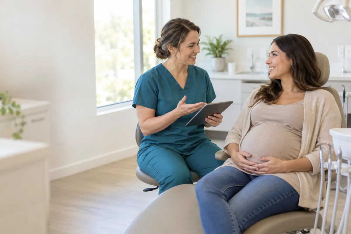 Pregnant adult seated upright while discussing dental care with a clinician