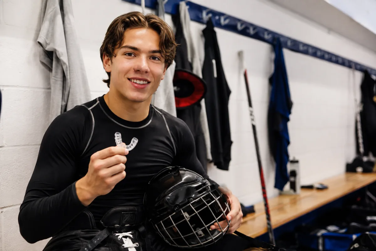 Young athlete holding a fitted sports mouthguard in Norfolk County
