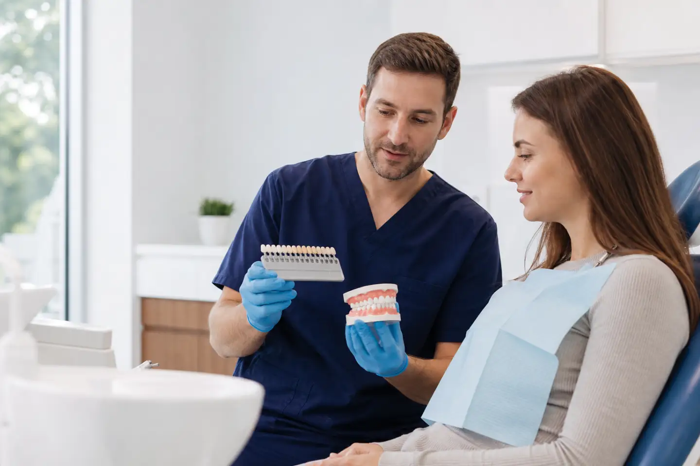 Dentist explaining tooth-coloured composite fillings with a shade guide