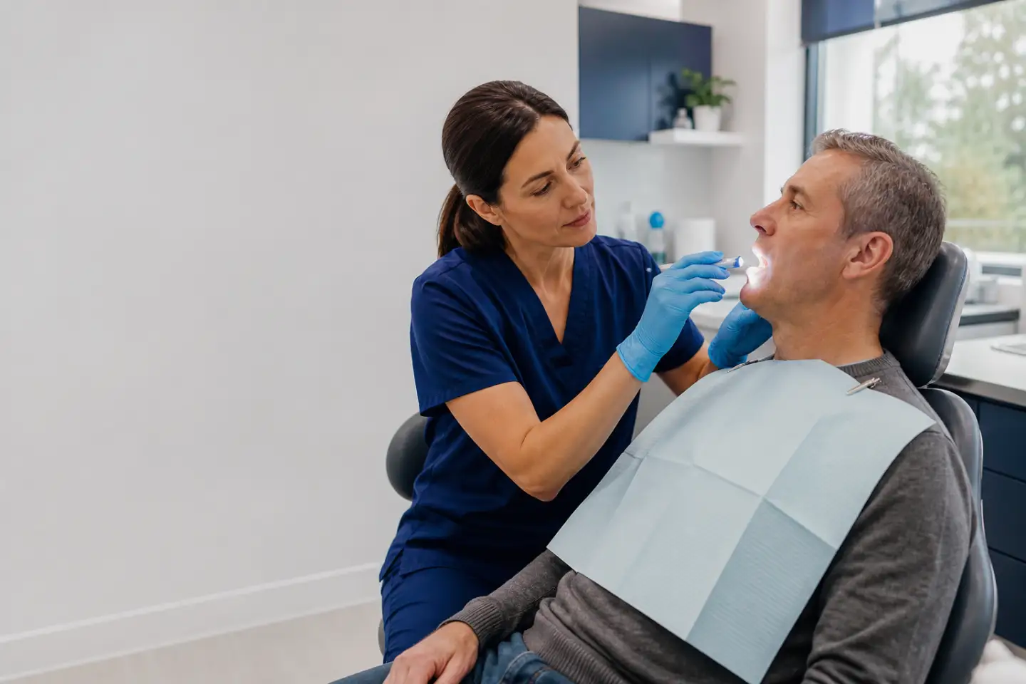Dental professional performing a gentle oral cancer screening